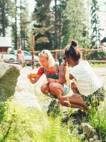 two women are taking a picture of a baby at White mountain Lodge in Kalvträsk
