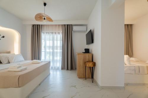 a hotel room with two beds and a television at Meltemi Marmaras in Neos Marmaras