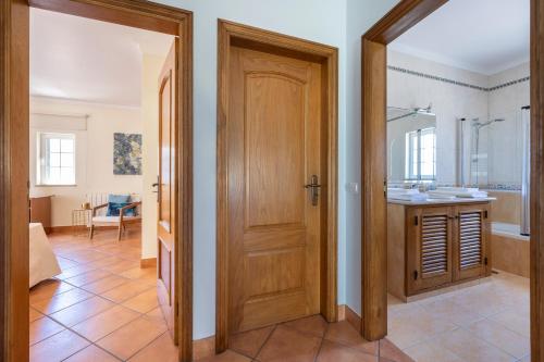 a bathroom with a wooden door and a sink at Casa Sunrise in Lagos