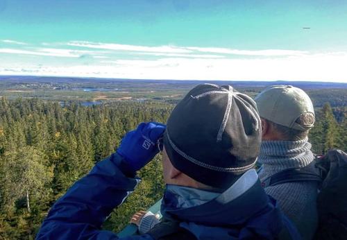two people standing on top of a hill looking at the view at White mountain Lodge in Kalvträsk