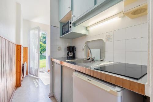 une cuisine avec un évier et un comptoir dans l'établissement 21 - La Mésange - Village vacances, à Maché
