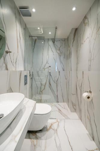 a bathroom with a white toilet and a sink at Meltemi Marmaras in Neos Marmaras