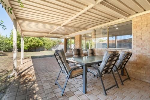 a patio with a table and chairs under awning at SPACIOUS JANDAKOT HOUSE FOR FAMILY AND BUSINESs in Perth