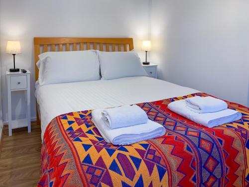 a bedroom with a bed with two towels on it at Tranquil Studio Retreat in Glastonbury in Glastonbury
