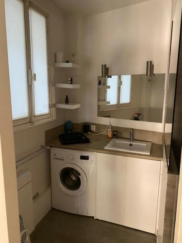une cuisine avec une machine à laver et un évier dans l'établissement Petit coin de paradis Paris 16, à Paris