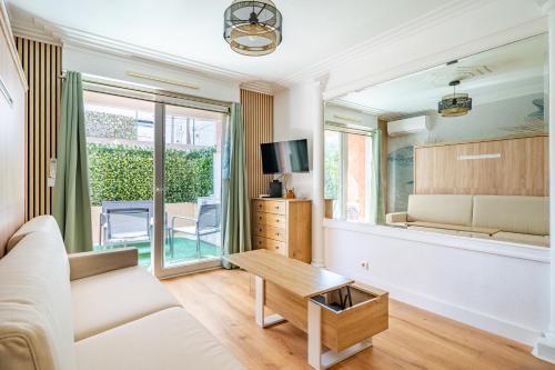 un salon avec un canapé et une table dans l'établissement Studio Jardin Parking et Clim, à Nice