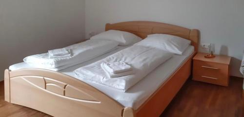 two beds with white sheets and pillows in a bedroom at Landlhof in Ramsau