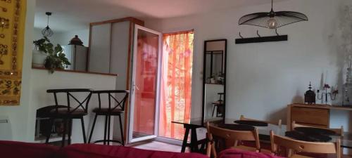 a living room with a table and chairs and a window at Maison conviviale avec jardin à Bras-d'Asse in Bras-dʼAsse