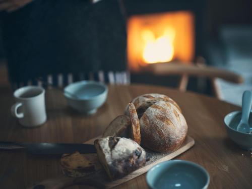 a table with a plate of bread on a table at SANU 2nd Home 軽井沢1st in Oiwake