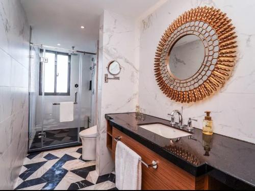 a bathroom with a sink and a mirror and a shower at Crystal Orange Shanghai Lingang Ocean Park Hotel in Nianbalian
