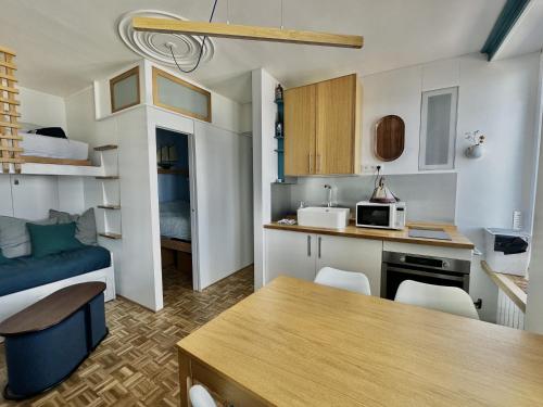 un petit appartement avec une cuisine et un salon dans l'établissement À l'est - Studio vue mer sur la digue, à Arromanches-les-Bains