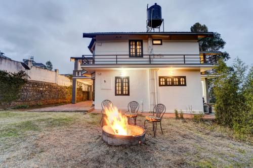 a fire pit in front of a house at Garden Haven 3 BHK Villa with Balcony and Verandah Escape in Kotagiri