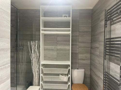 baño con vestidor con estanterías blancas en Olive Garden House, en Manor