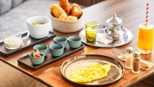 a breakfast table with eggs and bread and drinks at Cruiser Mogador Essaouira in Essaouira