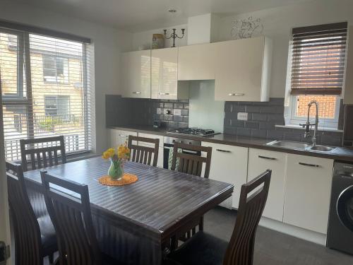 a kitchen with a wooden table with chairs and a dining room at Olive Garden House in Manor