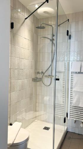 a bathroom with a shower and a toilet at Hotel Berliner Hof by Coffee Fellows Hotels in Kiel