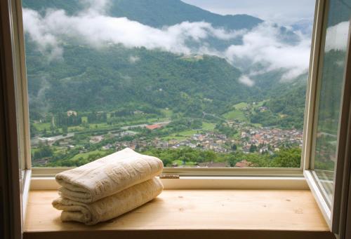 an open window with a view of a mountain at Da Gigi Alpine Rooms in Crandola Valsassina