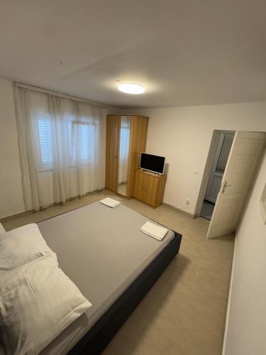 a bedroom with a bed and a television in it at Lili apartman in Vodice