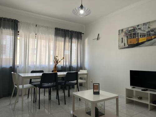 a dining room with a table and chairs and a tv at OFIR NATURE in Fão