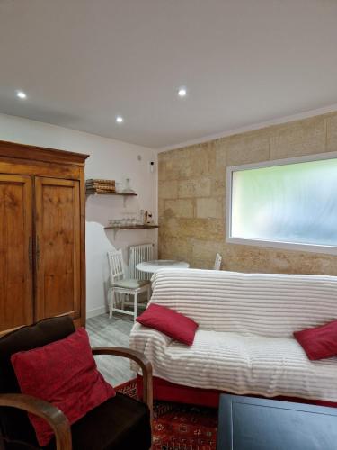 a living room with two beds and a large window at La maison des vendangeurs in Libourne