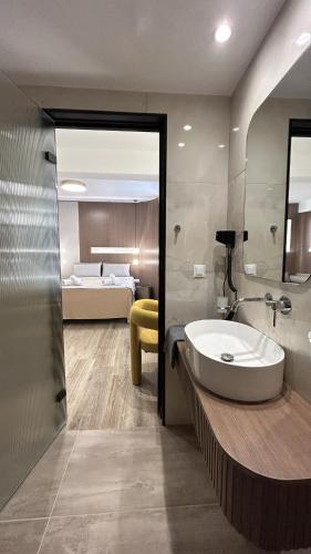 ロードス・タウンにあるMorfeas City Hotelのバスルーム(シンク付)、ベッド1台が備わります。