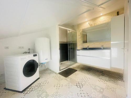 a bathroom with a washing machine and a sink at Maison en pierre de Caen charmante et confortable et sa terrasse privative entre terre et mer in Bretteville-sur-Odon