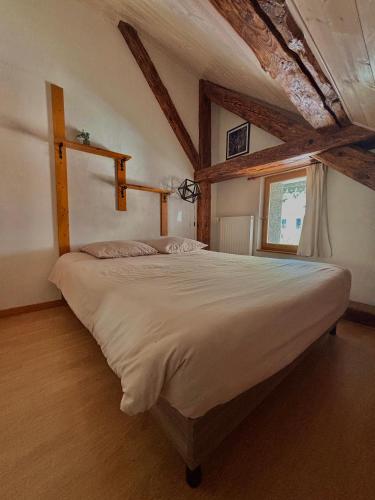 une chambre avec un grand lit dans une pièce dans l'établissement MAISON NGP, à Aigueblanche