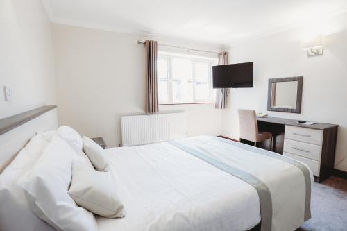 a bedroom with a large white bed and a desk at The Appleby Inn Hotel in Appleby Magna