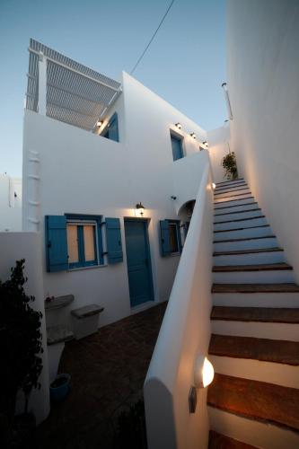 a staircase leading to a white house with blue doors at Casaprimavera in Katapola