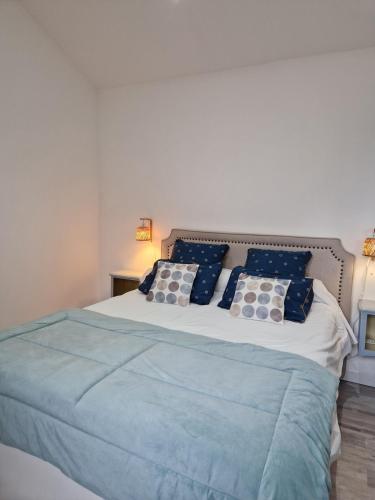a bedroom with a large bed with blue and white pillows at La maison des vendangeurs in Libourne