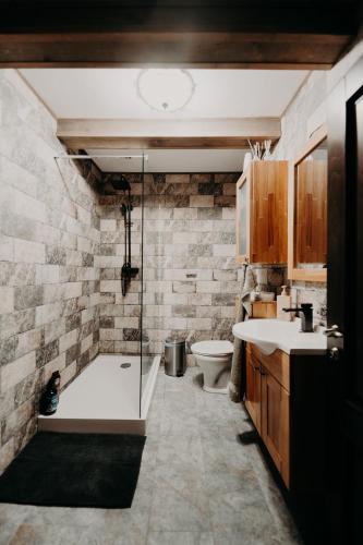 a bathroom with a tub and a sink and a toilet at Moonlake Chalet in Găineşti