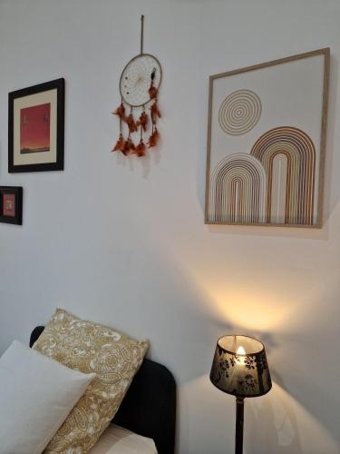 a bedroom with a bed and a lamp and a painting at La maison des vendangeurs in Libourne