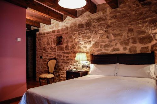 a bedroom with a bed and a table and a chair at Hotel Rural Nobles de Navarra in Áibar
