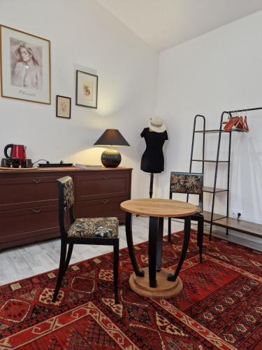 a room with a table and two chairs and a dresser at La maison des vendangeurs in Libourne