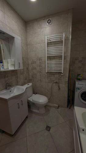 un baño con inodoro y lavabo en Rustaveli Luxe Residence, en Tiflis