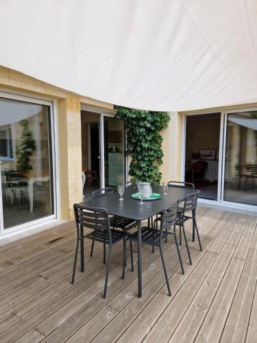 a black table and chairs on a wooden deck at La maison des vendangeurs in Libourne
