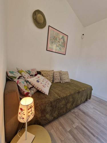 a living room with a couch and a lamp at La maison des vendangeurs in Libourne