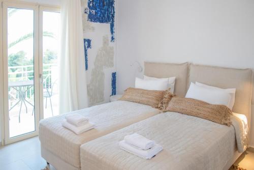 a bedroom with a white bed with towels on it at Princess Hotel in Lassi