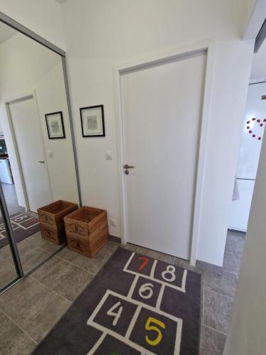 a room with a white door and a rug on the floor at La maison des vendangeurs in Libourne