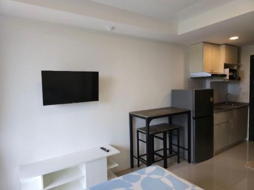 eine kleine Küche mit einem kleinen Tisch und einem Kühlschrank in der Unterkunft 777 Beach Condotel in Mai Khao Beach