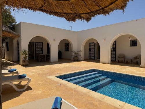 a swimming pool in the middle of a courtyard with a house at Dar Yasmine in Triffa