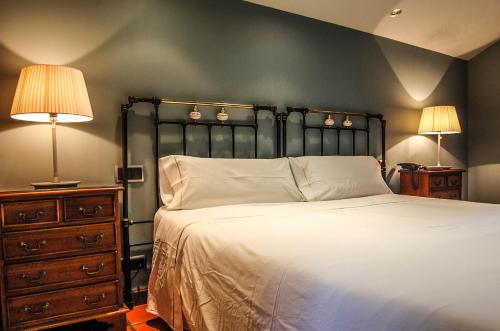 a bedroom with a bed with two lamps and a dresser at Hotel Rural Nobles de Navarra in Áibar