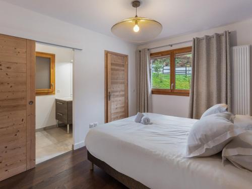 une chambre avec un grand lit blanc et une fenêtre dans l'établissement Appartement moderne avec 3 chambres, terrasse, garage et services inclus à Megève - FR-1-569-131, à Megève