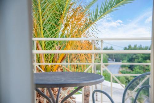 a table on a balcony with a palm tree at Princess Hotel in Lassi