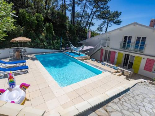 une piscine avec deux canards en caoutchouc à côté d'une maison dans l'établissement Villa d'Exception: Piscine Chauffée, SPA, pour 14, à 5 min du Lac d’Hossegor - FR-1-791-20, à Soorts-Hossegor