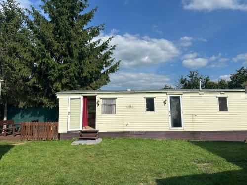 a white house with a red door in a yard at Autocamp Free Star - Mobilheimy in Strachotín