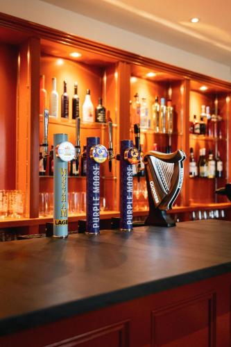 a bar with a counter with different bottles of alcohol at Plas Weunydd in Blaenau-Ffestiniog