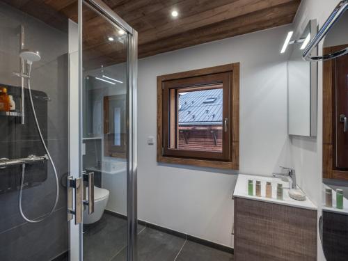 une salle de bain avec douche et toilettes et une fenêtre dans l'établissement Appartement rénové au centre de Megève avec balcon et parking - FR-1-569-137, à Megève