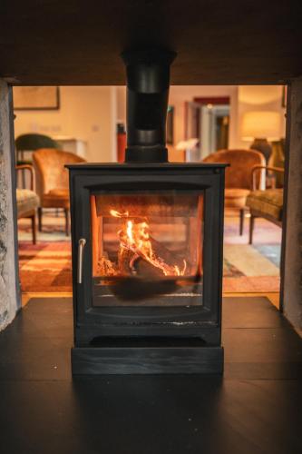 a fireplace in a living room with a fire in it at Plas Weunydd in Blaenau-Ffestiniog