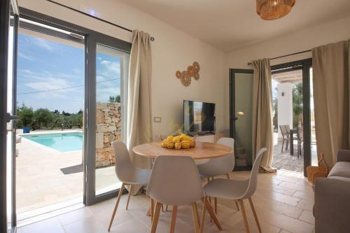 a dining room with a table and chairs and a pool at TD Trullo Diamante – Pure Relaxation Privacy in Putignano